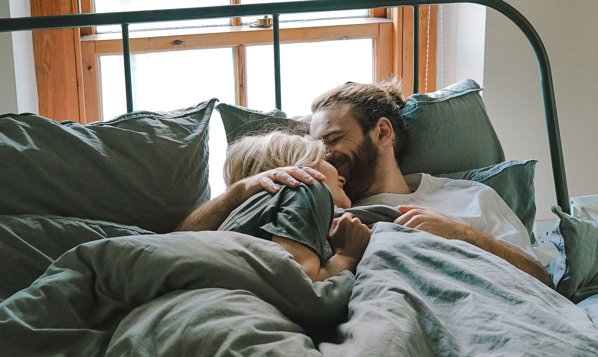couple kissing in bed